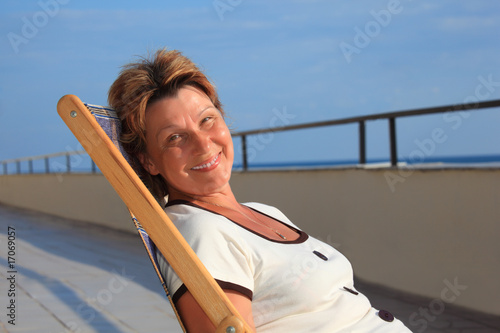 middleaged woman in lounge on veranda over sea © Pavel Losevsky