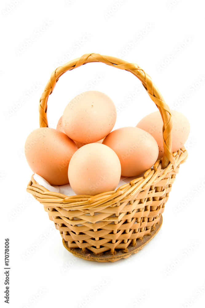 cane basket with chicken eggs over white background cane basket with chicken eggs over white background
