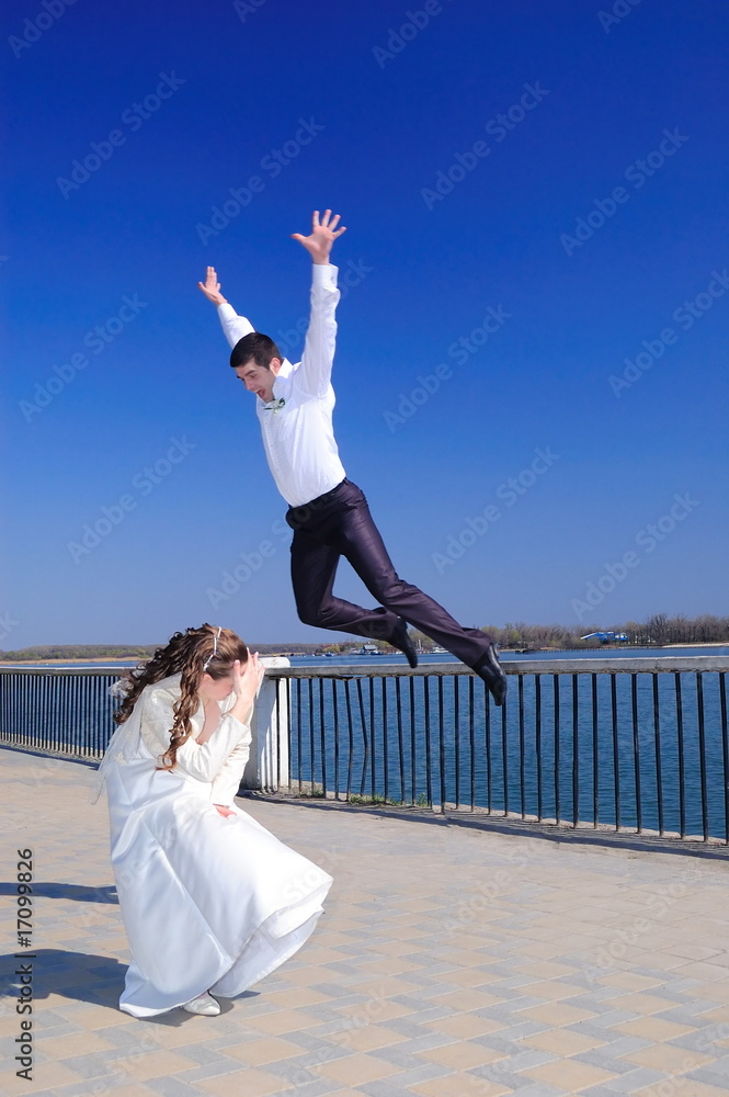 The groom jumps on the bride