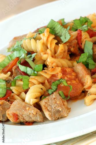 Pasta with baked tomato, meat and basil