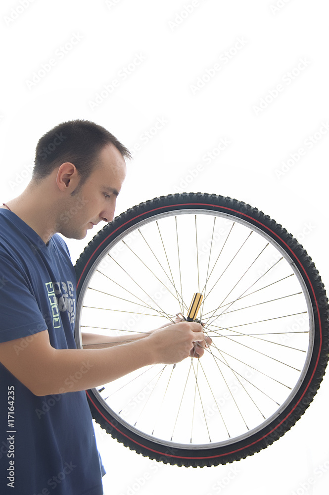 joven reparando rueda de bicicleta