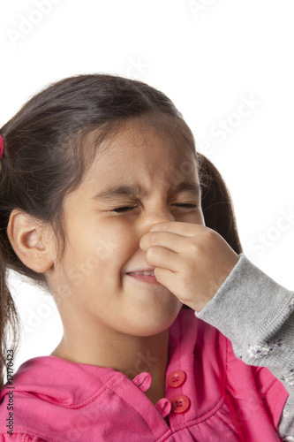 Little girl is closing her nose for a terrible smell