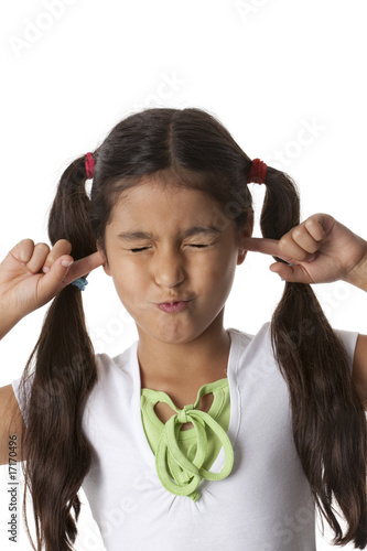 Little girl is closing her ears with her fingers photo