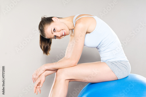 Sportliche junge Frau mit Gymnastik-Ball