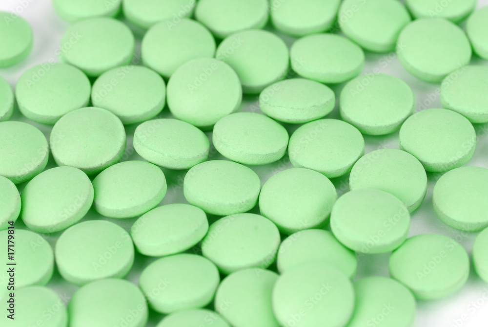 green pills on white with a shallow depth of field