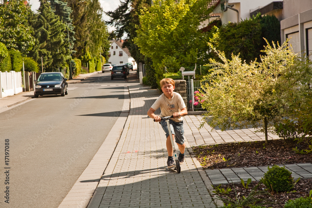 Kind übt Roller Scooter fahren, Tricks auf dem Bürgersteig Kind übt Roller Scooter fahren, Tricks auf dem Bürgersteig