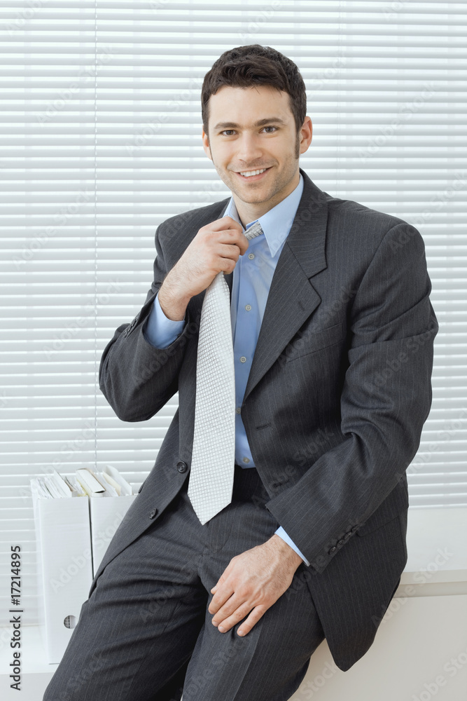Businessman adjusting tie