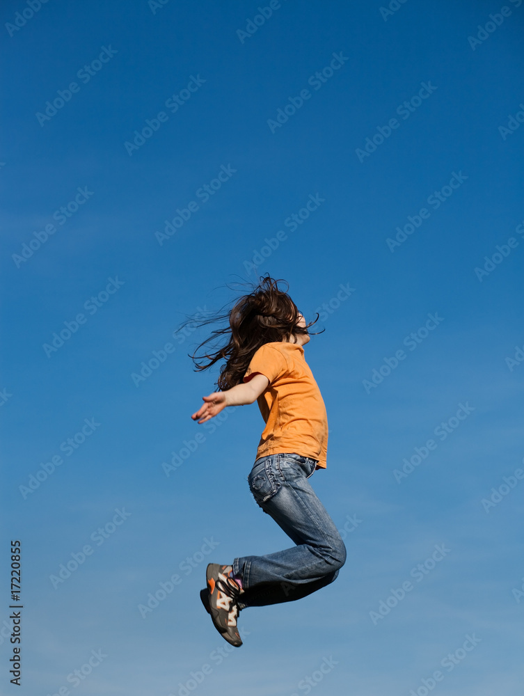 Girl  running, jumping against blue sky