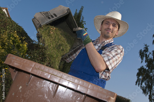 Rasenmäher Mann leert den Fangkorb in Biotonne