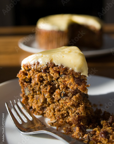 Carrot cake slice with whole cake in the background