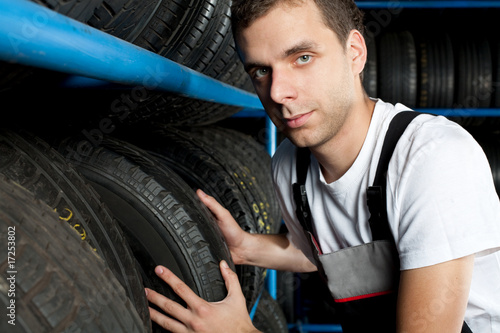 Young mechanic choosing tire in car service © baranq