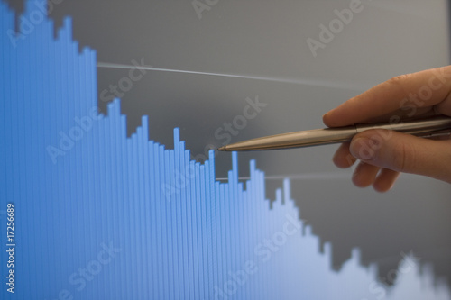 Businessman's hand showing diagram on financial report with pen