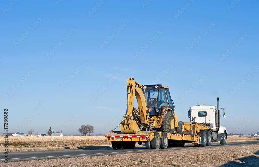 Semi-truck hauling a back-hoe loader combination Semi-truck hauling a back-hoe loader combination