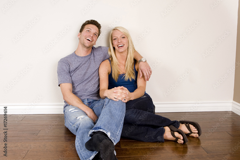 Attractive young couple sitting in their new home Attractive young couple sitting in their new home