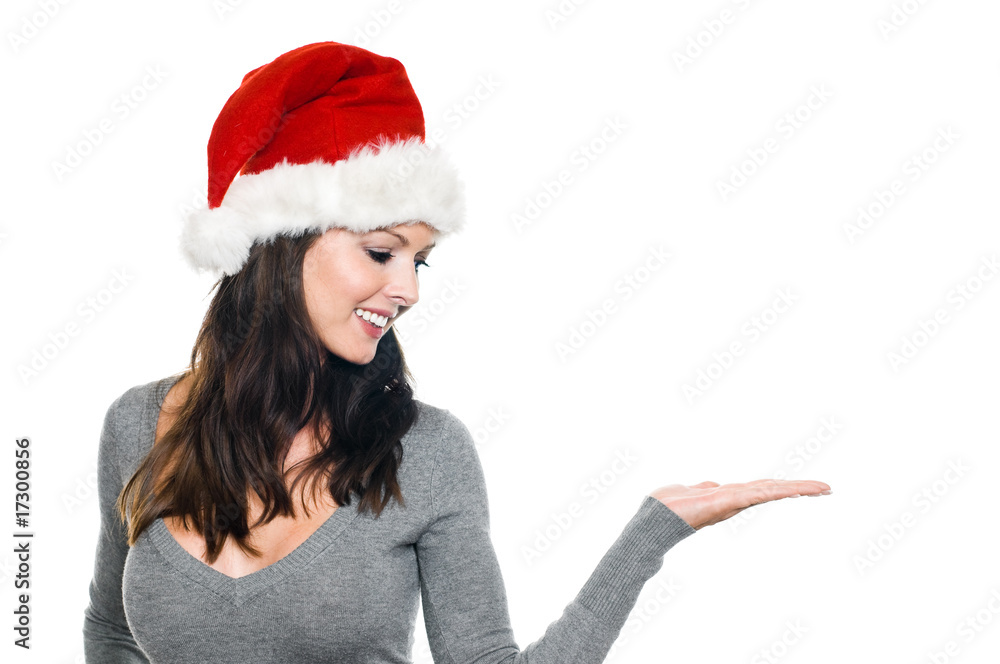 Frau mit Weihnachtsmütze präsentiert vor weißem Hintergrund Frau mit Weihnachtsmütze präsentiert vor weißem Hintergrund