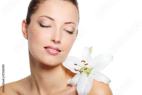 Serene face of a beauty fresh woman with flower on shoulder