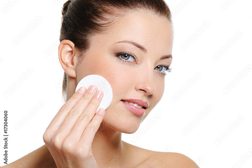 Woman cleaning her face with cotton swab Woman cleaning her face with cotton swab