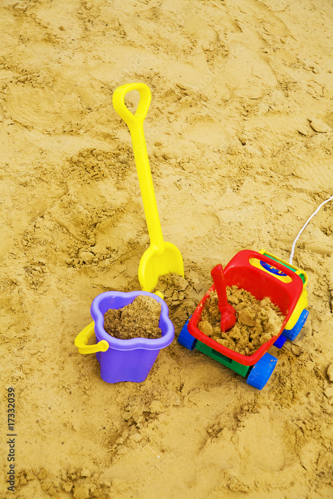 bright child's toys in sand on a playground bright child's toys in sand on a playground