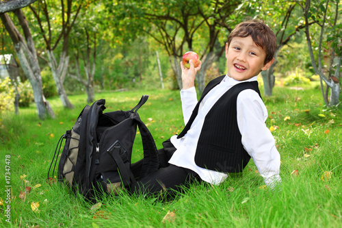 schoolboy with backpack and apple outdoors © konstantant