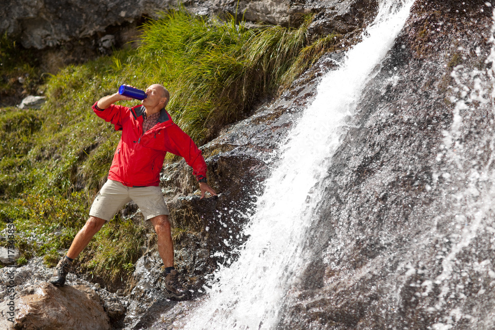 hiker drinking at waterfall