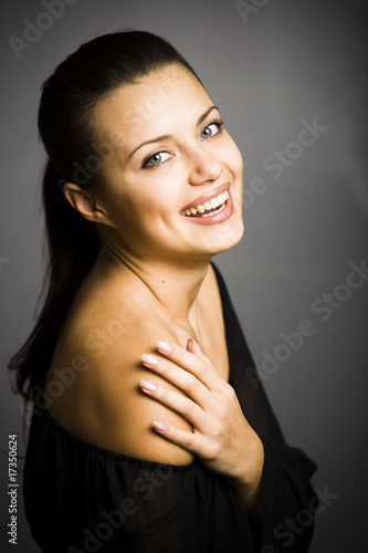 smiling young woman touching her shoulder