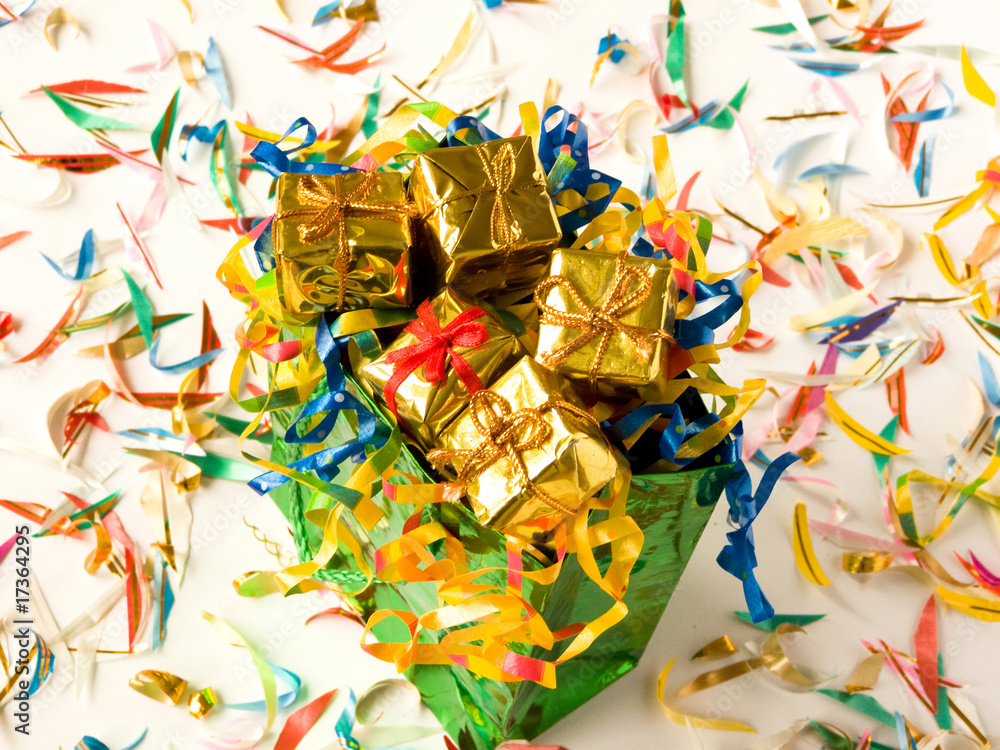 Bag full of small golden gifts around confetti. Shallow DOF.