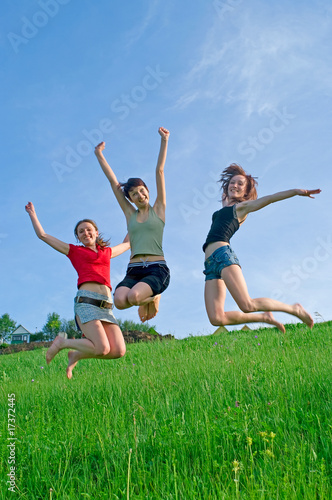 Girls jump on the meadow