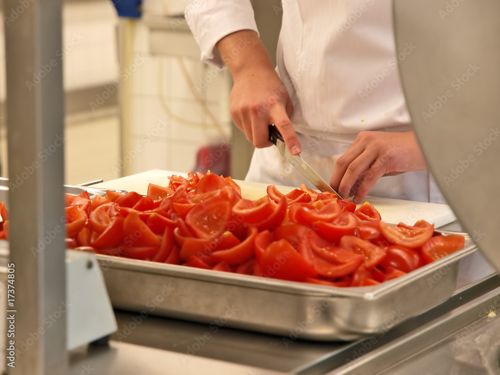 Professioneller Koch schneidet und entkernt viele Tomaten als Kochvorbereitung