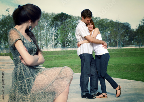 Happy young pair in park under a steadfast spiteful sight photo