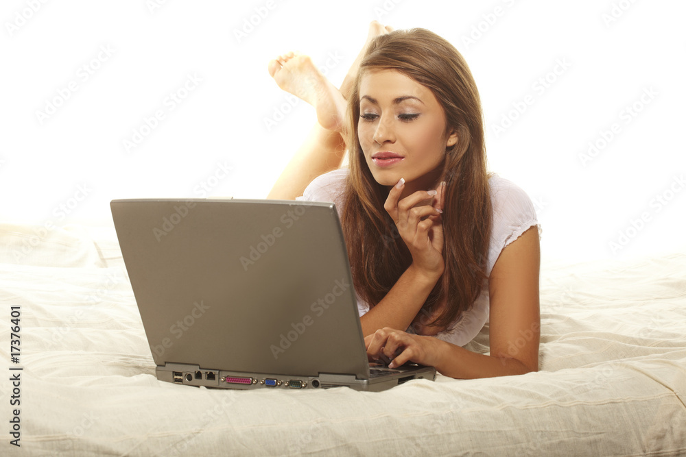 young woman lying on sofa using laptop young woman lying on sofa using laptop