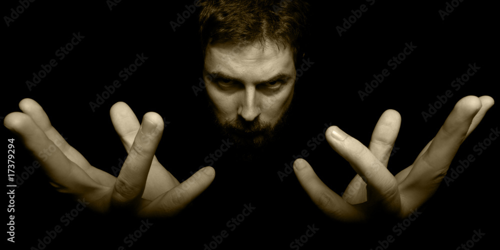 Hands and face of evil magician in the dark Hands and face of evil magician in the dark