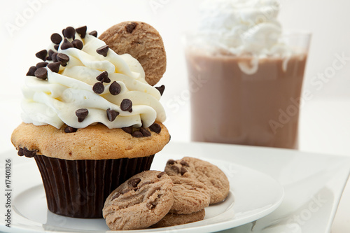 A Chocolate Chip Cookie Cupcake With Hot Chocolate In The Backgr