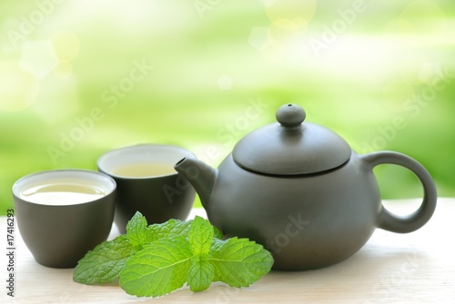 Teapot and cups with mint leaves