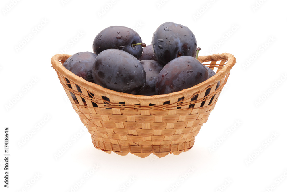 plums in basket on white background plums in basket on white background