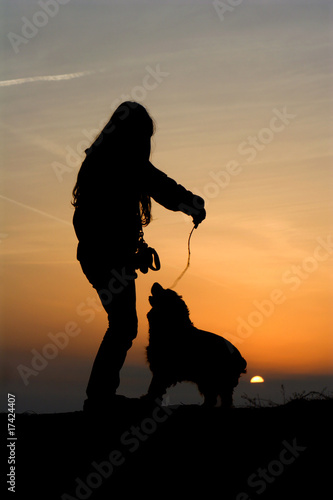 child and dog in sunset - silhouette