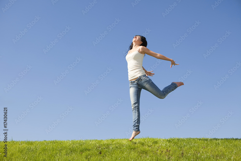 pretty young woman jumping on green grass pretty young woman jumping on green grass