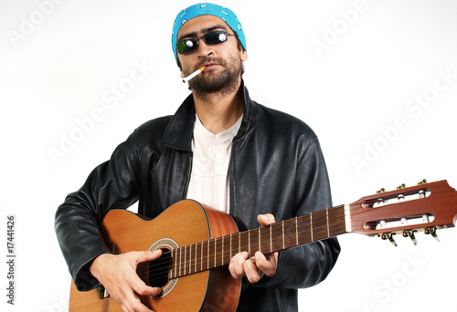 young guy in dark glasses and bandana  with a guitar