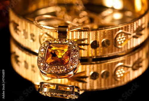 Golden bracelet and jewelry on dark background