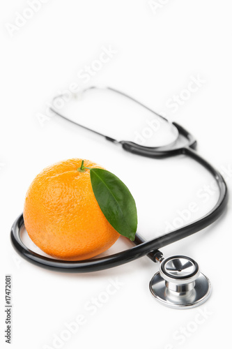 Stethoscope and orange over white
