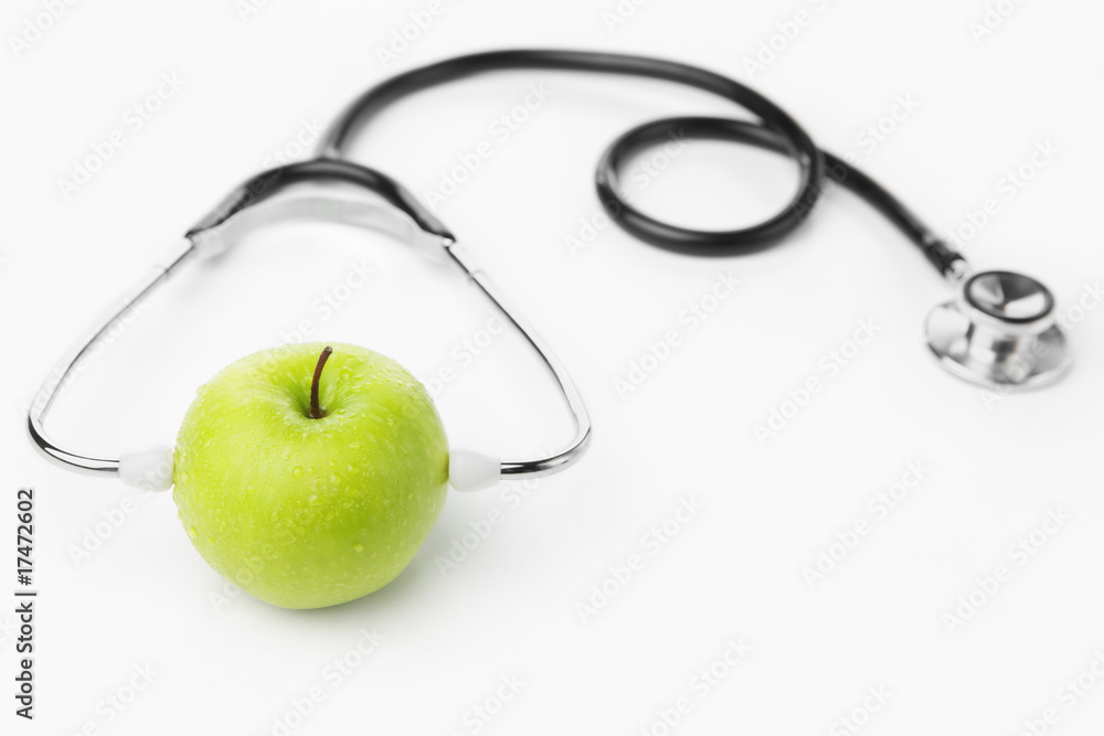 Green apple wearing stethoscope over white Green apple wearing stethoscope over white