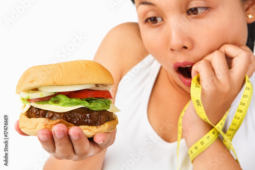 Young female surprisingly looking at burger