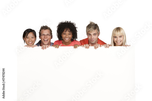Group of happy students holding white board