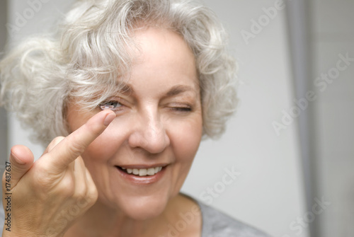 ältere Frau begutachtet genauer eine Kontaktlinse