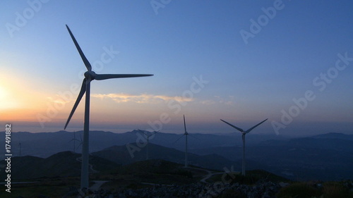 Wind turbine generator in the mountains at sunset