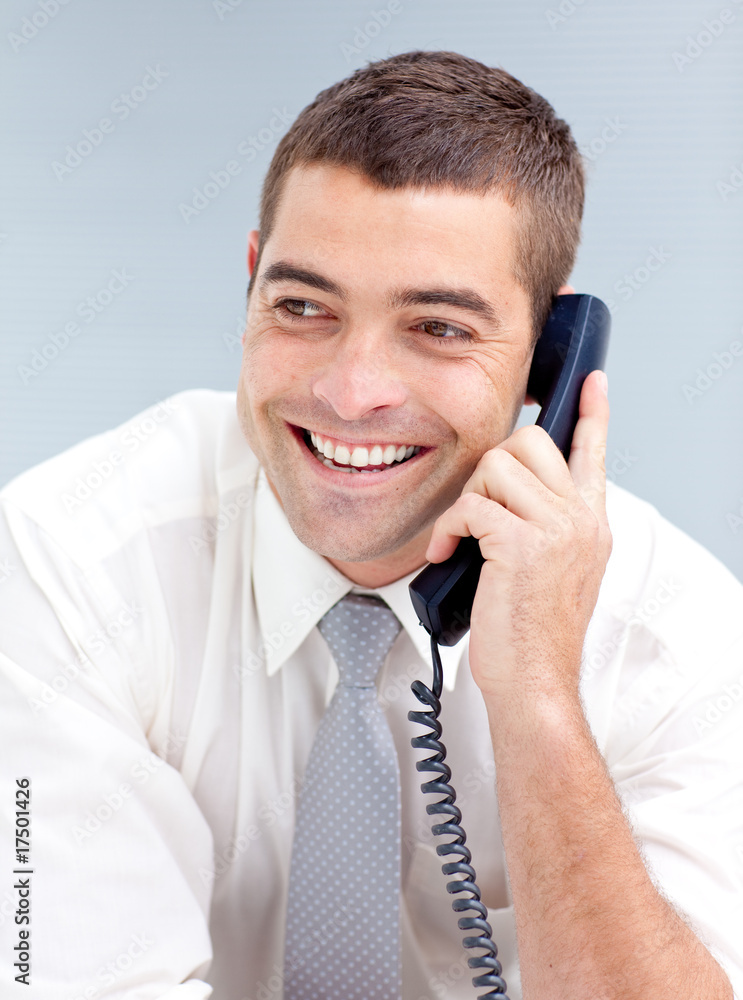 Smiling businessman in office talking on phone Smiling businessman in office talking on phone