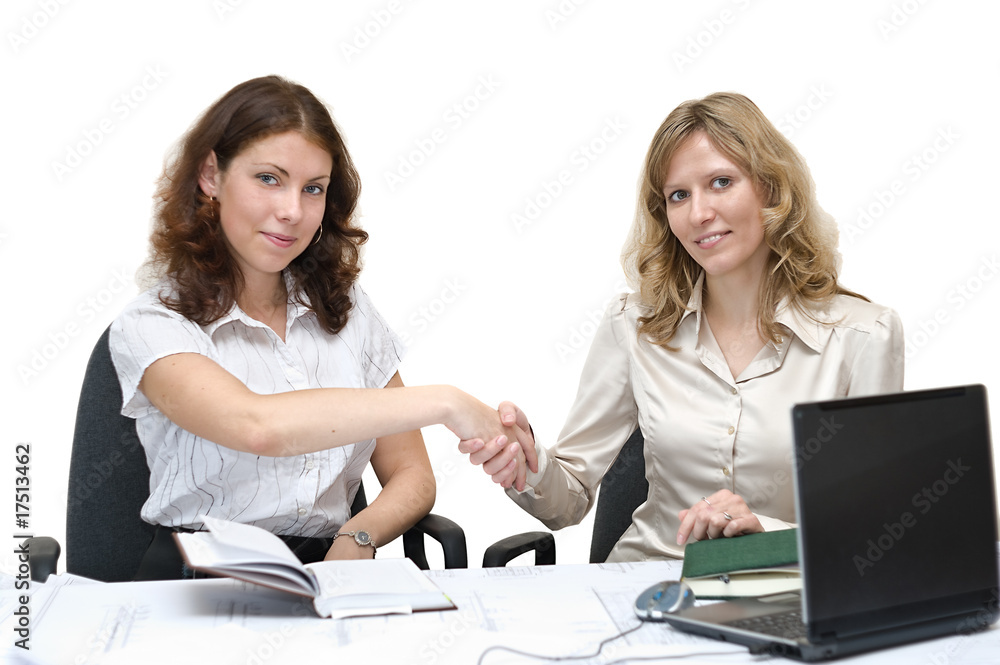 Two young beautiful businesswomen sitting at desk Two young beautiful businesswomen sitting at desk