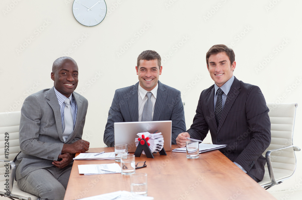 Three businessmen in a meeting smiling Three businessmen in a meeting smiling