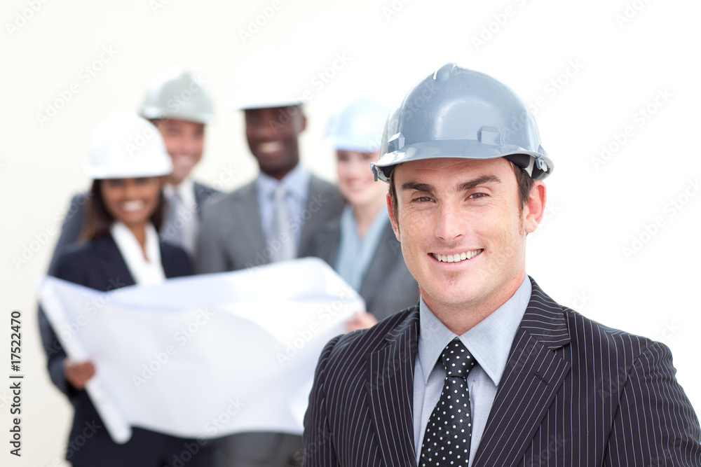 Attractive male architect with his team in the background Attractive male architect with his team in the background