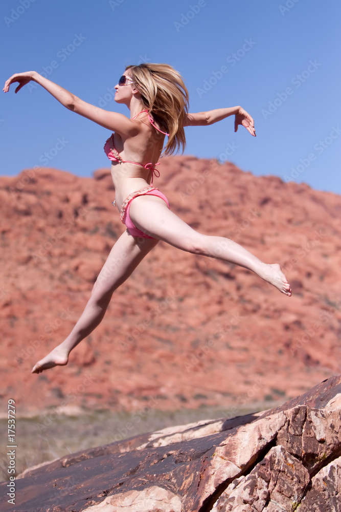 Woman in bikini jumping outdoors