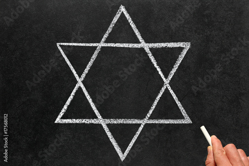 Drawing Star of David Judaism religious symbol on a blackboard.